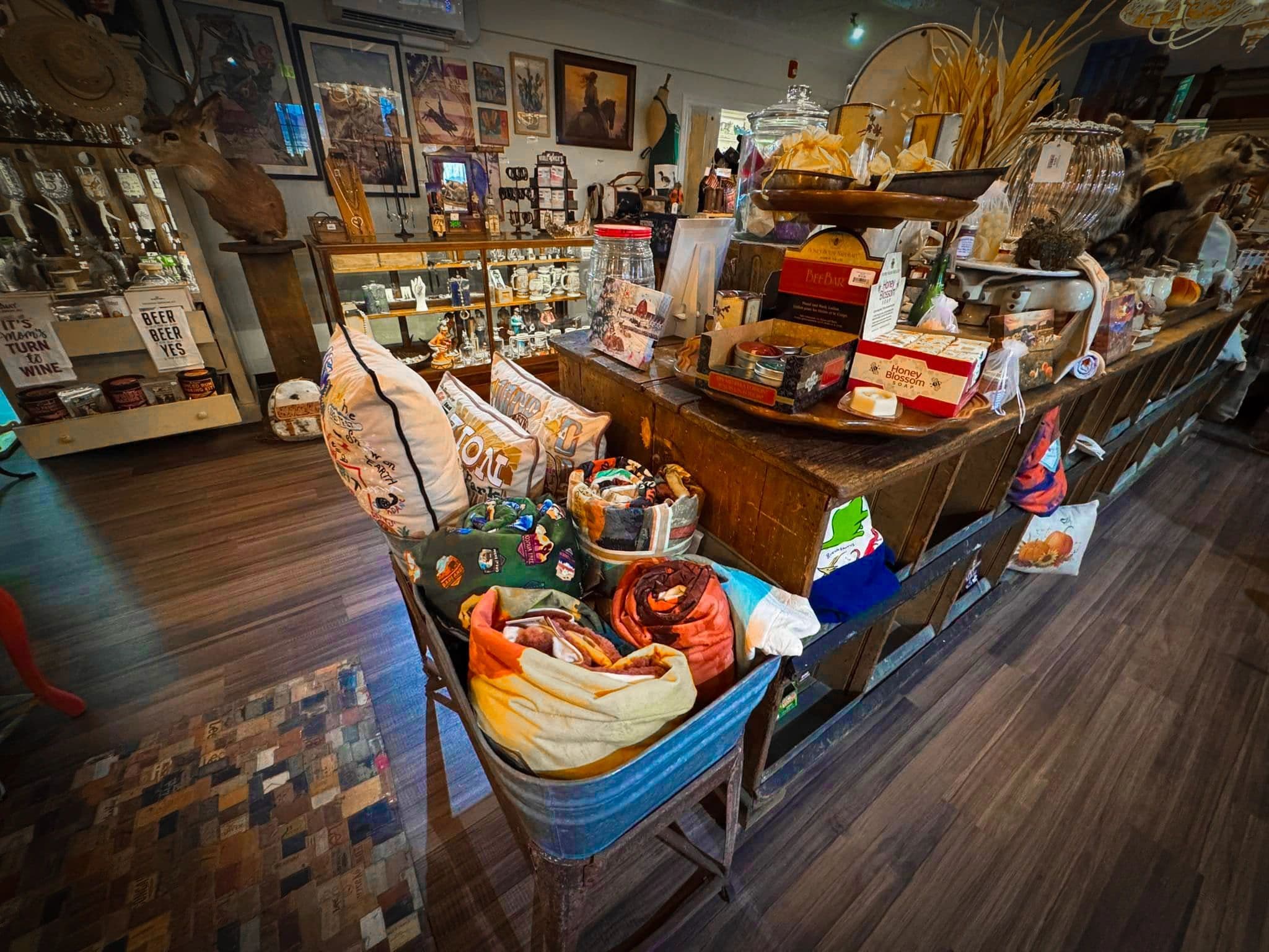 Inside the Sweet Tea & Whiskey Living Gift Emporium — a curated counter of Western goods, textiles, jewelry, and art.